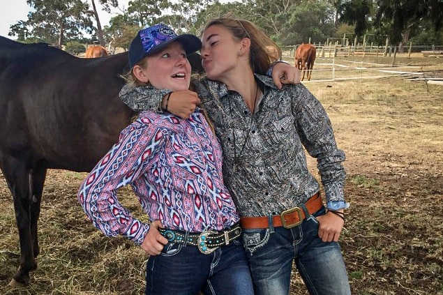 Two young girls wearing western clothes playing. 