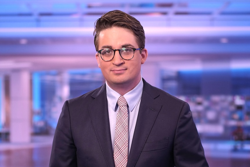 A young man in a suit and glasses. 