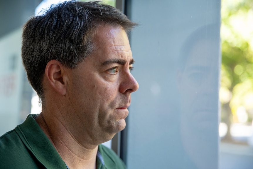 A man looks outside a window