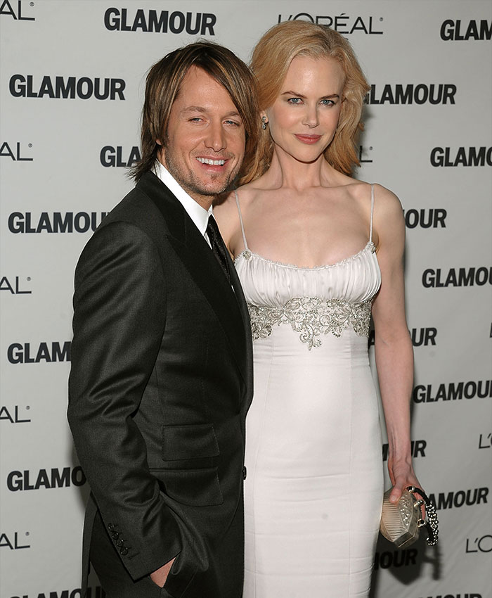 Nicole Kidman and Keith Urban posing together at a Glamour event in formal attire with smiles. Nicole Kidman and Keith Urban posing together at a Glamour event in formal attire with smiles.