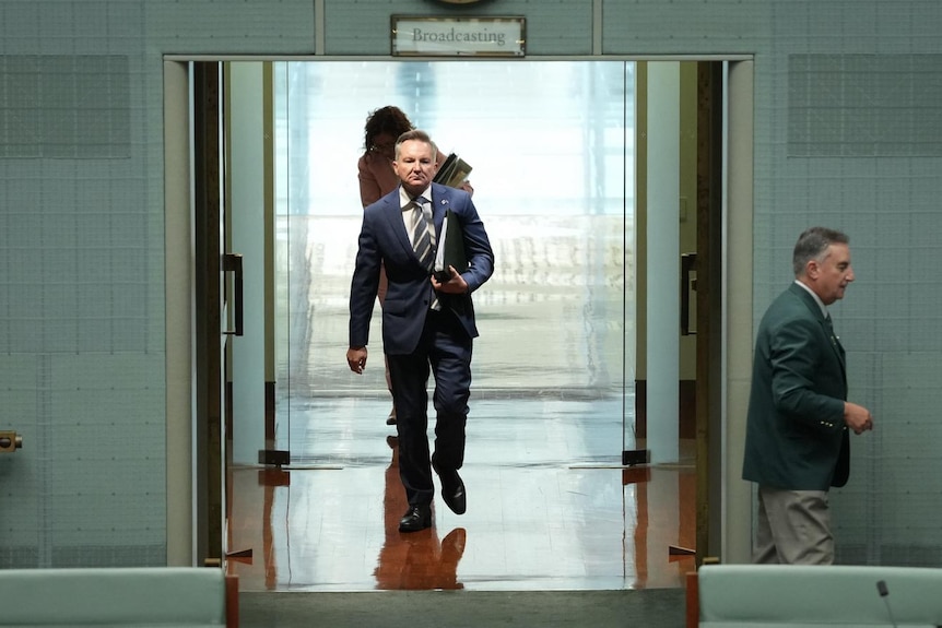 A man walking along a corridor.