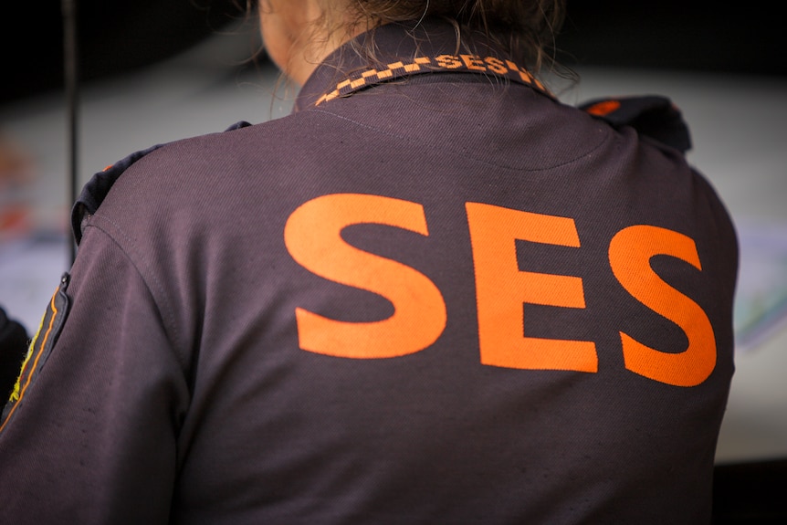 An SES volunteer wears the navy and orange uniform.