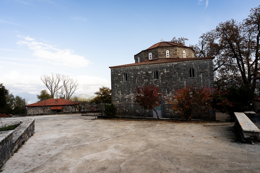 An empty public square behind a stone church.