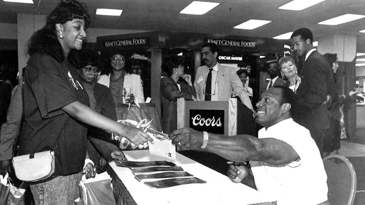 Lee Haney handing out signed books in a bookstore.