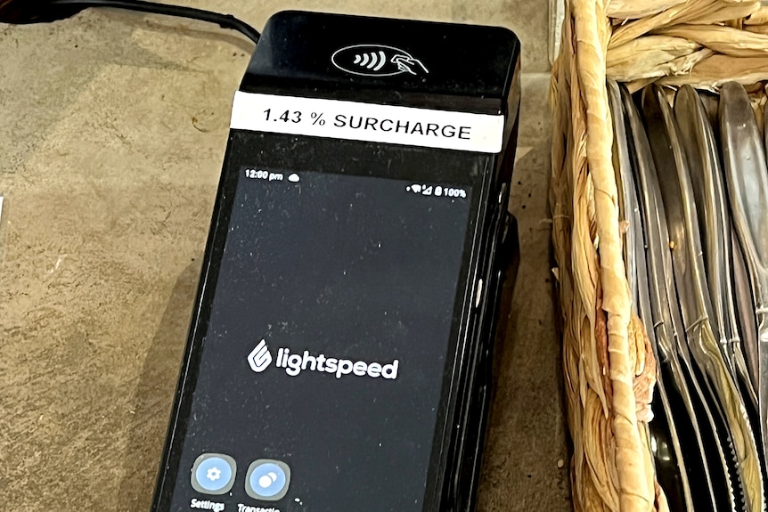 Eftpos machine with a surcharge note on it