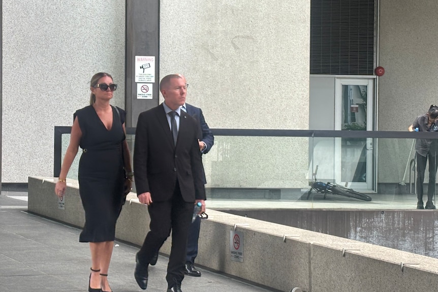 A woman and man dressed foramlly leaving a courthouse