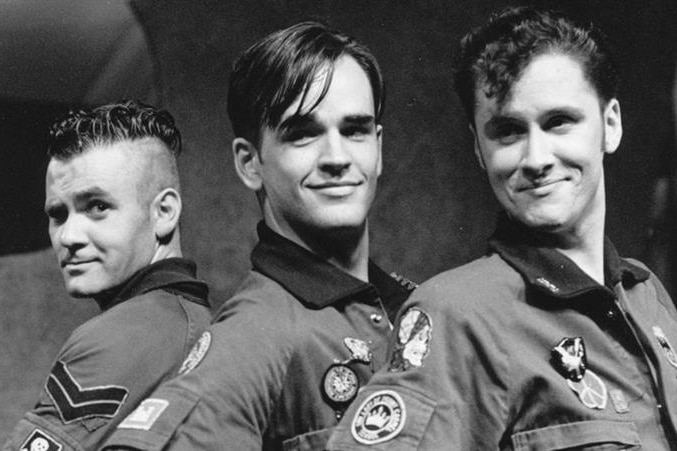 Three members of Doug Anthony All Stars pose together, smiling.