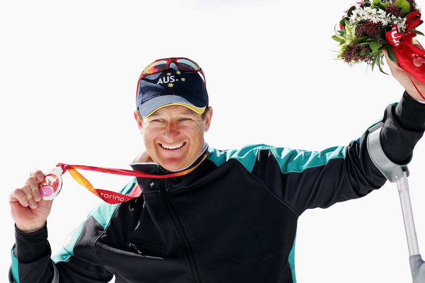 Michael Milton celebrates with his medal and a bouquet of flowers