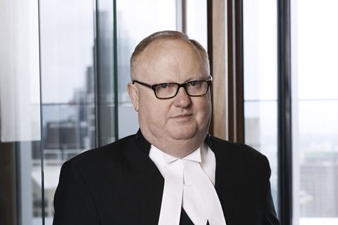 A serious-looking man in a barrister's white tie.