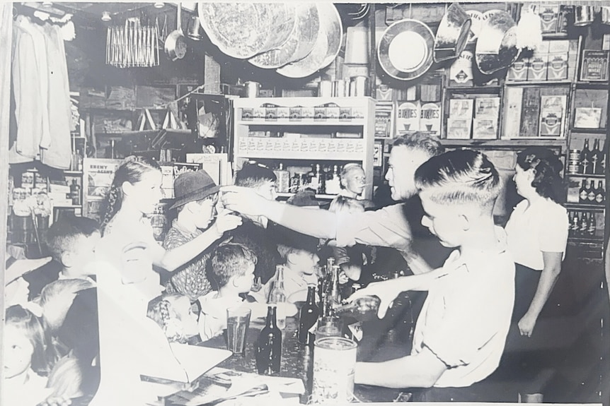 A black and white image of schoolchildren being served at a regional general store.