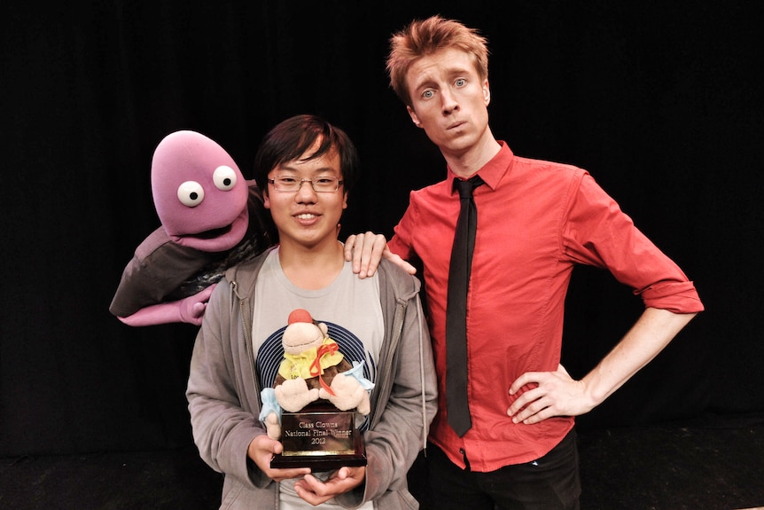 Aaron Chen and Sammy J pose with a purple puppet, Randy Feltface.