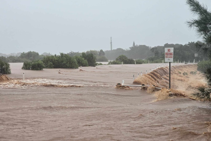 Brown flooded water over a road.