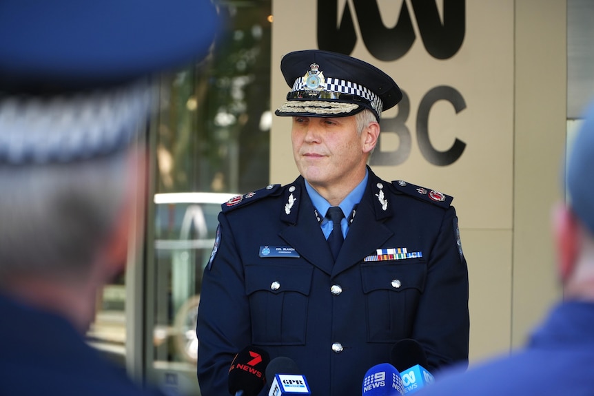 WA Police Commissioner Col Blanch standing in front of microphones with a wall displaying an ABC logo behind him.