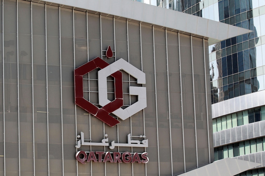 symbol red and white on a building and words qatar gas.