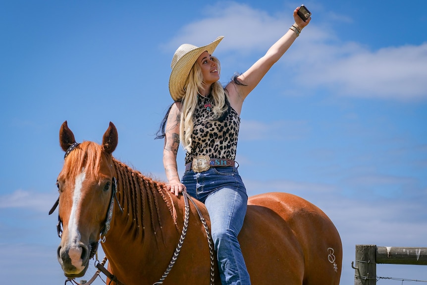 A woman takes a selfie on a horse