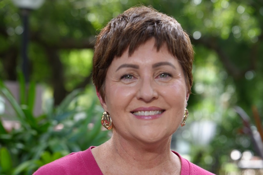 a woman in a pink jumper with short hair