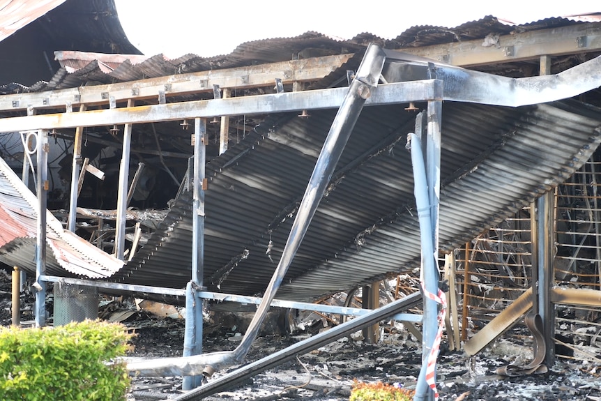 A sagging piece of roof with burnt debris underneath