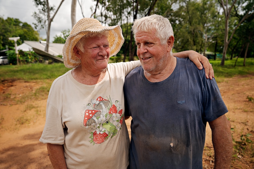 A wife and husband with their arms around each other.