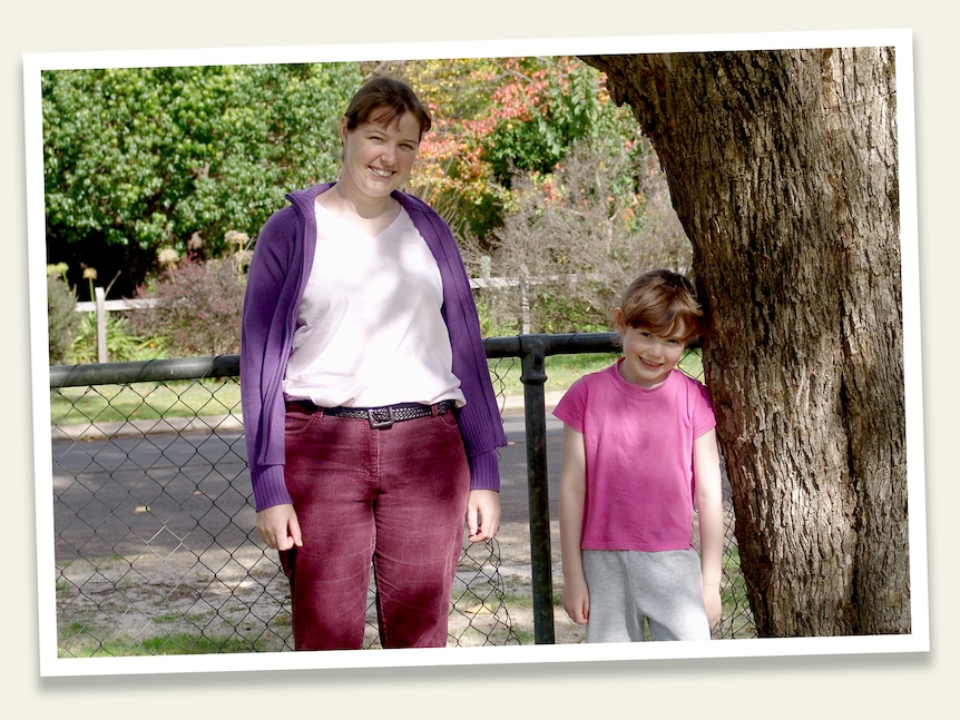 A women in a purple cardigan and a young girl in a pink shirt.
