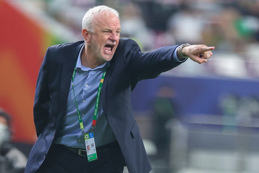 Graham Arnold shouts and points with passion during a game