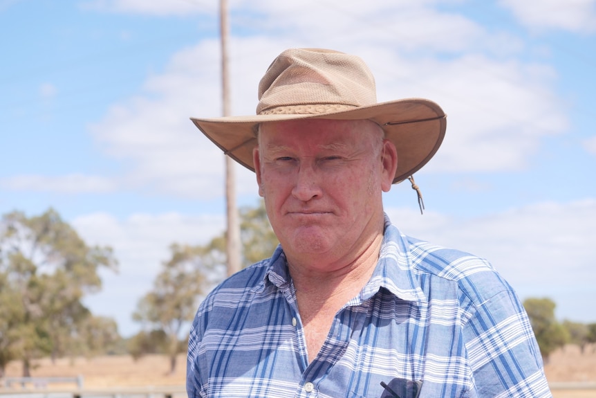 Portrait shot of farmer Oscar Negus, he is wearing a checked shirt and wide-brim hat.