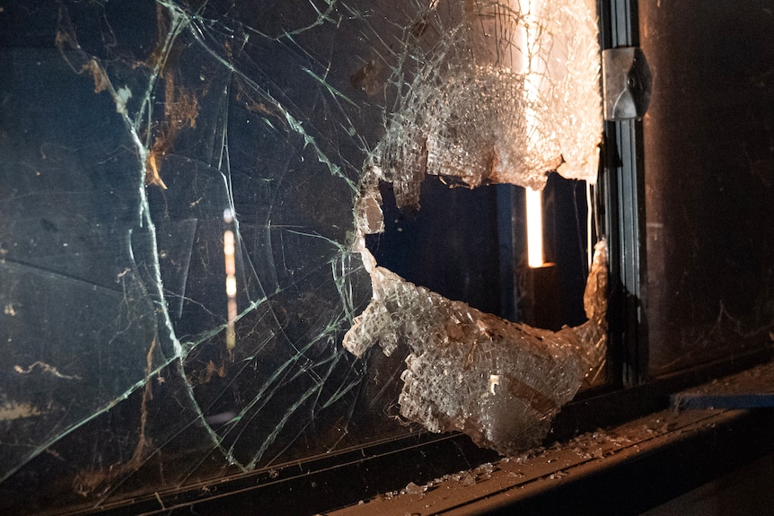 Some light shines through a badly cracked window.