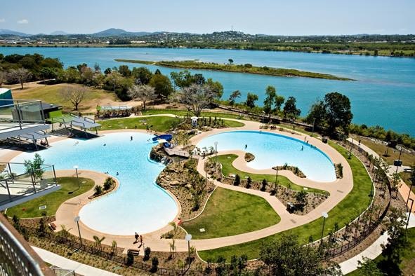 Two swimming pools with a river in the background.
