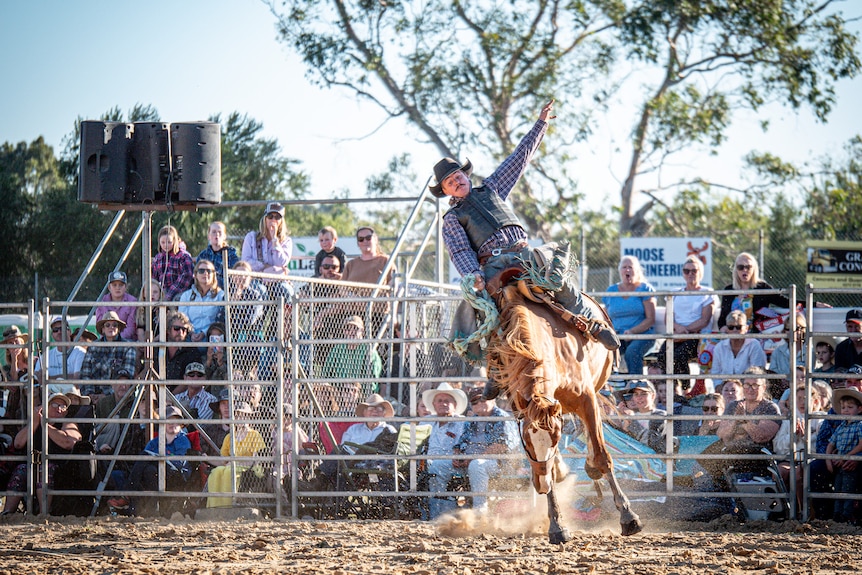 A man on horseback puts his arm out.