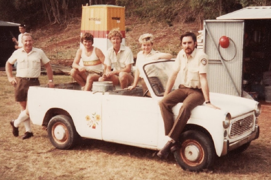 Five park rangers pose with a small ute in Queensland in the 1980s.