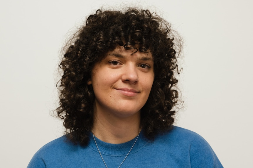 a woman with curly hair smiling gently