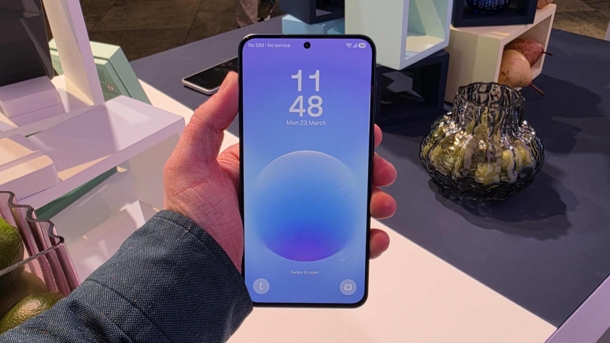 The Samsung Galaxy A57 in a man's hand, on its lock screen.