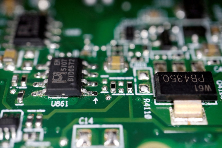Closeup of green circuit board components in a semi conductor chip.