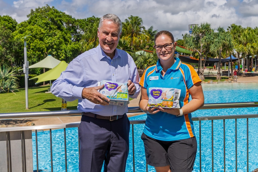 The Mackay Mayor and the Blue Water Lagoon venue manager stand in front of Blue Water Lagoon holding free nappies.