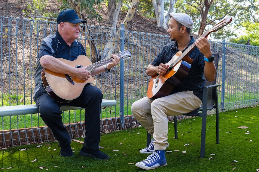 Two men playing guitars.