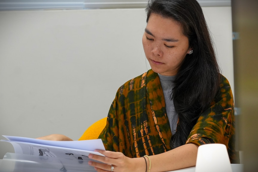 a woman with a shawl on looking at bits of paper