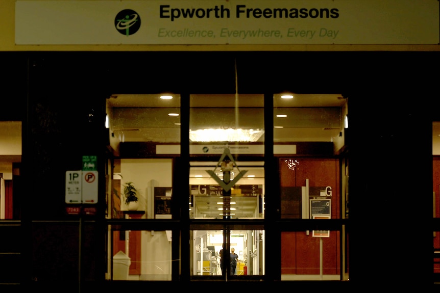 The doors of a hospital building at night. A hallway can be seen. Above is a sign saying 'Epworth Freemasons'.