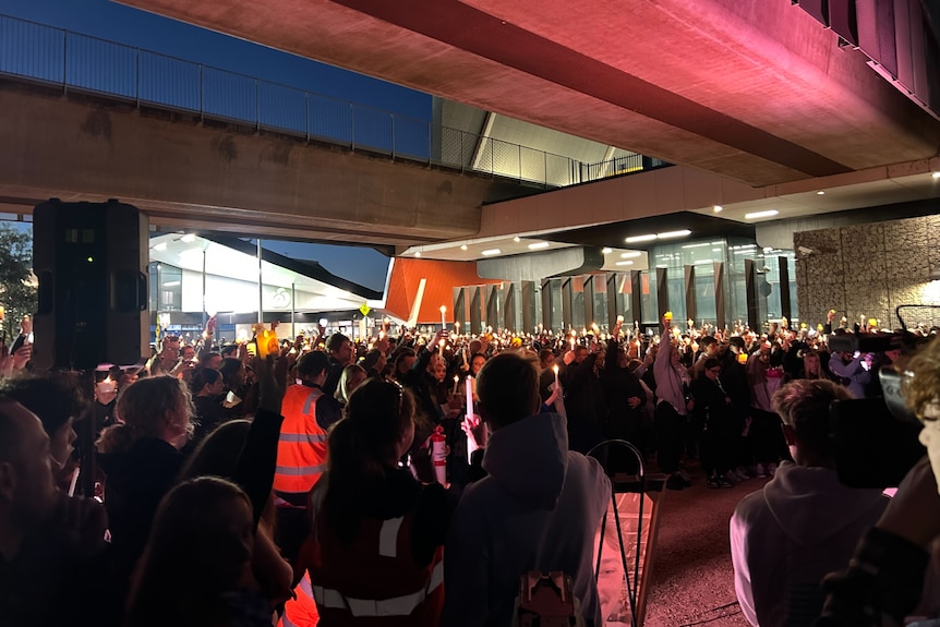 Thousands of people hold up candles during a minute's silence at the vigil