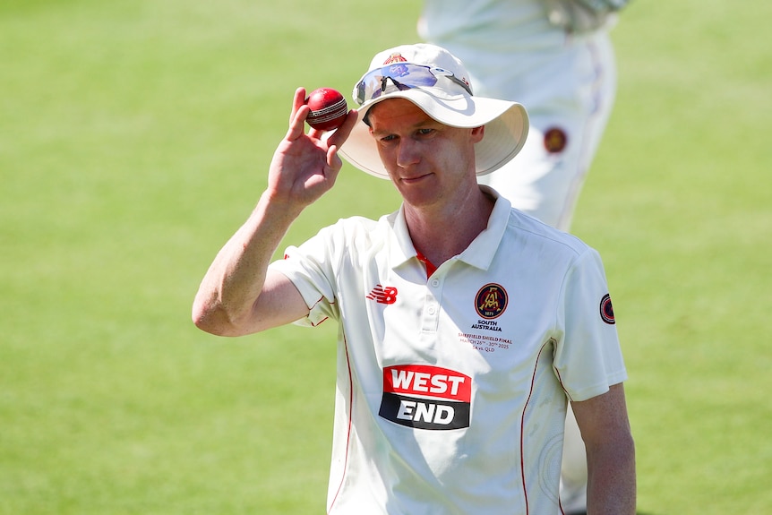 Brendan Doggett of South Australia celebrates six wickets, raising the cricket ball to acknowledge applause