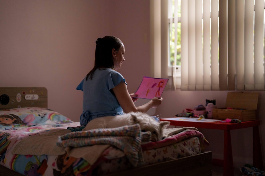 Naomi Cate, Advocate and Founder of Ashermans Australia, looks at her daughter's drawings.