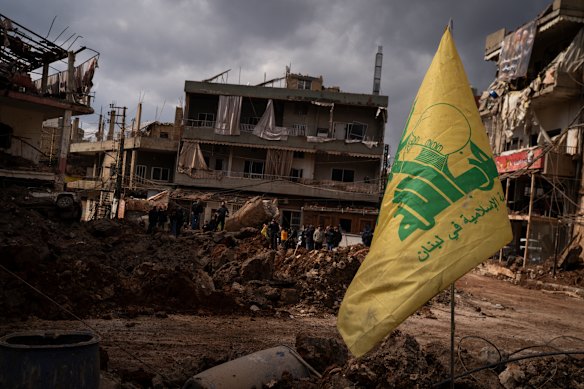 A Hezbollah flag is seen in front of buildings destroyed by heavy airstrikes in Nabi Chit, Lebanon. 