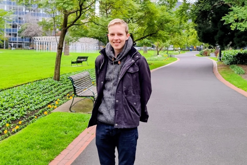 A man standing amongst a very well kept garden