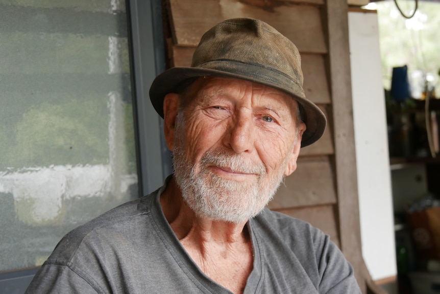 A man with a white beard and hat smiles.