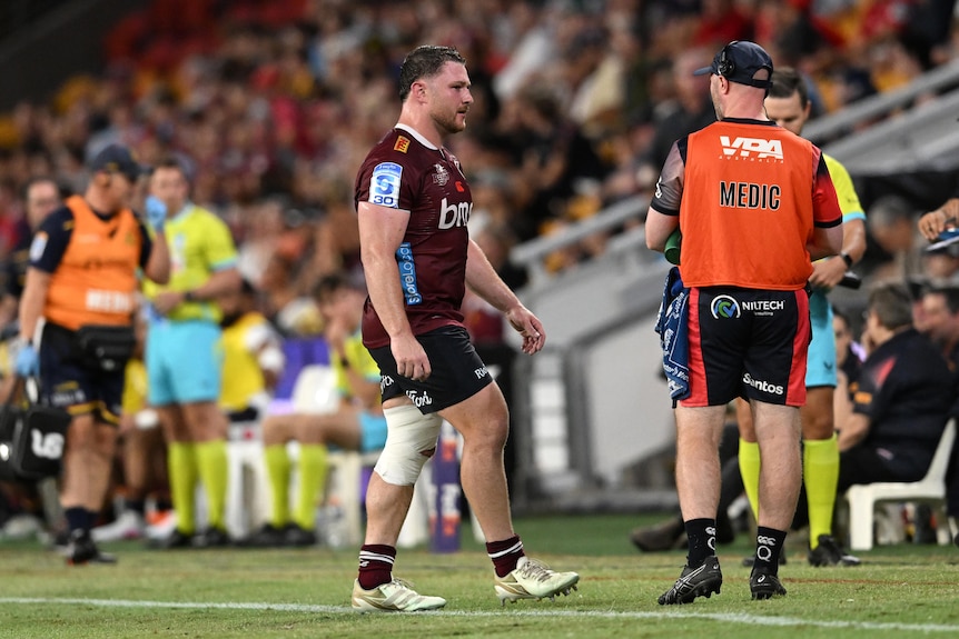 Matt Faessler of the Reds is seen leaving the field, limping