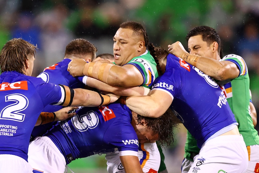 A man runs the ball during a rugby league match 