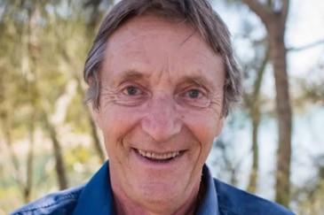 Headshot of an older man smiling at the camera. 