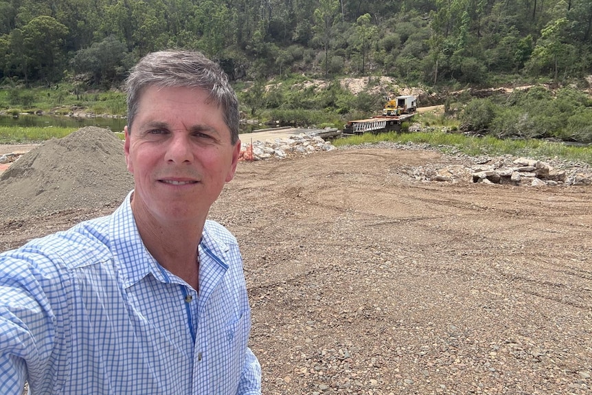 A man standing in front of gravel.