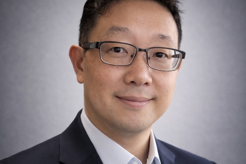 Corporate mugshot of man in a suit jacket and shirt