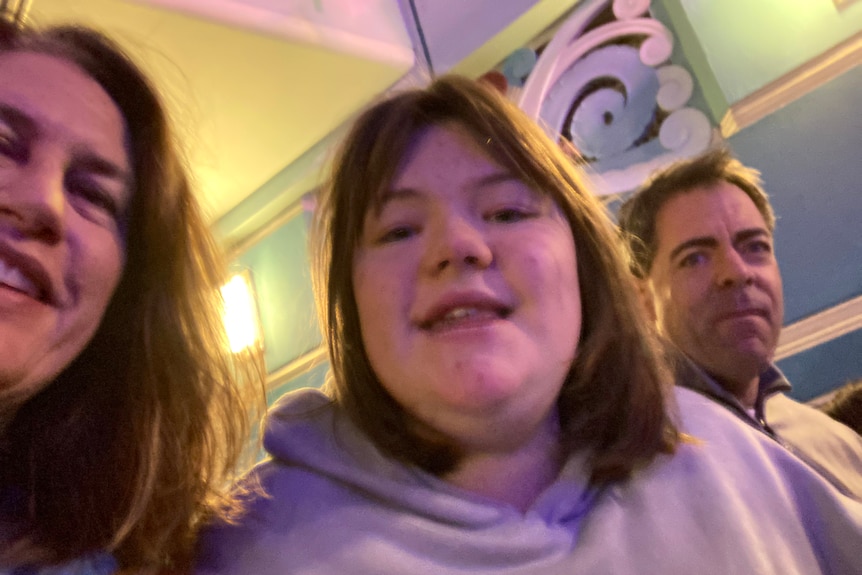 Headshot from below of a teenager girl and her parents.