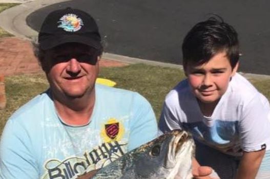 man and boy with fish