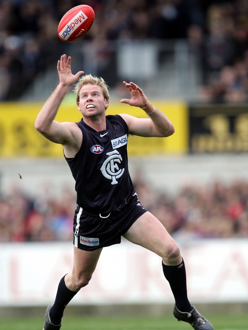 Nick Stevens reaches for the football while playing for Carlton in an AFL match.